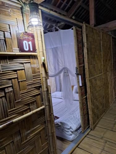 uma porta de madeira com uma cama dentro em Muong Bi Homestay em Hòa Bình