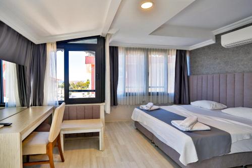 1 dormitorio con 2 camas, escritorio y mesa en Side Güneş Otel en Side
