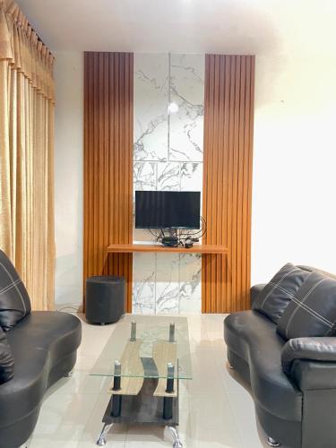 ein Wohnzimmer mit einem Sofa und einem Glastisch in der Unterkunft Apple eight 2BR Villa in Batu