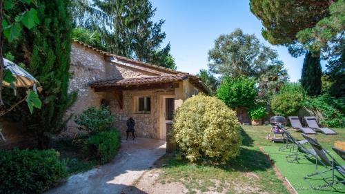una pequeña casa de piedra con un patio con sillas en I love Bergerac Cottage, en Bergerac