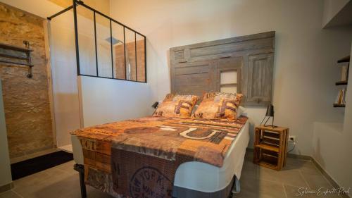 Schlafzimmer mit einem großen Bett mit einem Kopfteil aus Holz in der Unterkunft I love Bergerac Cottage in Bergerac