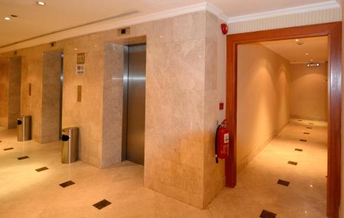 a hallway with a fire extinguisher in a building at Hayah Grand Hotel Ex Al Jaad Madinah Hotel in Medina