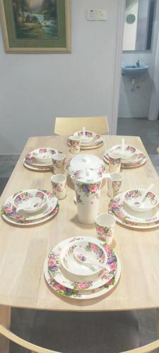 a table with china plates and cups on it at Relaxing Retreats at Cocobay Apartments in Port Dickson