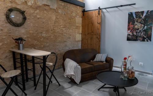 ein Wohnzimmer mit einem Sofa und einem Tisch in der Unterkunft I love Bergerac Cottage in Bergerac