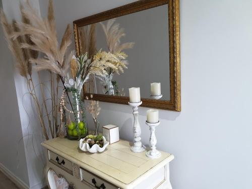 a dressing table with a mirror and candles on it at Snug & cozy ensuite in a new house in Officer