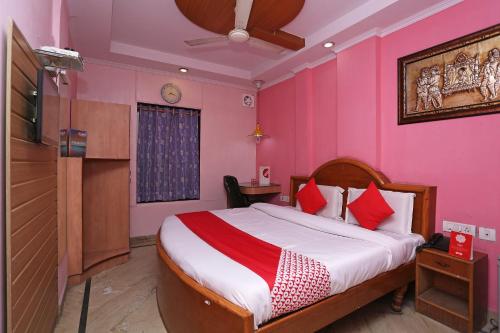 1 dormitorio con 1 cama grande y paredes de color rosa en OYO Hotel Madhur Regency, en Meerut