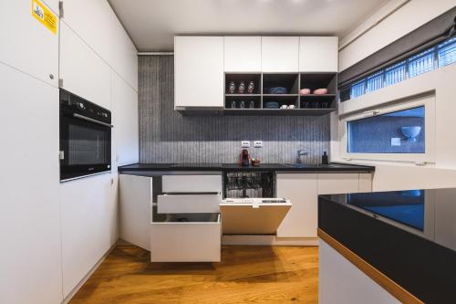 une cuisine avec des placards blancs et un comptoir noir dans l'établissement Charming 2 Bedroom Apartment, à Cluj-Napoca