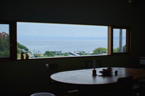 a table in a room with a large window at WORM in Awaji