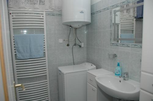 małą łazienkę z toaletą i umywalką w obiekcie Zöldike Vendégház w mieście Kaposvár