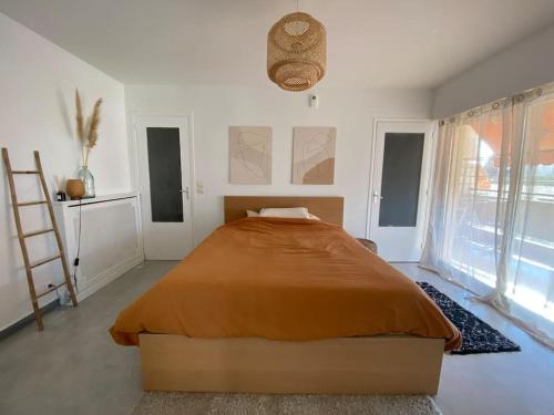 - une chambre avec un grand lit dans une pièce dotée de fenêtres dans l'établissement Appartement avec terrasse, à Cannes