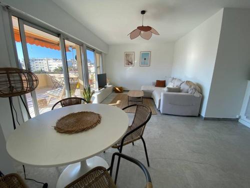 un salon avec une table, des chaises et un canapé dans l'établissement Appartement avec terrasse, à Cannes