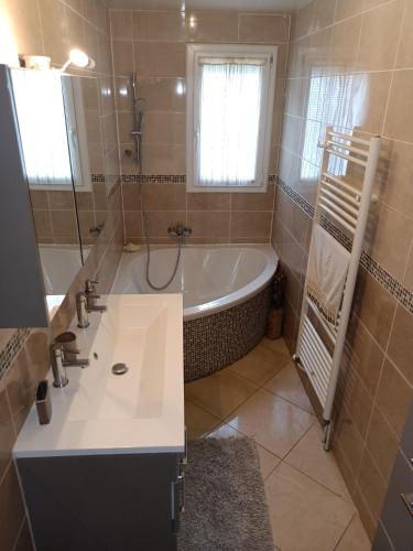 une salle de bain avec une baignoire et un lavabo dans l'établissement Maison Aubergenville Elisabethville, à Aubergenville