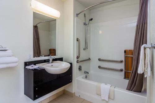 uma casa de banho com um lavatório, uma banheira e um chuveiro em Motel 6-College Station, TX - Bryan em College Station