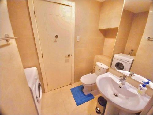 a small bathroom with a toilet and a sink at Modern-Eclectic 1BR- Unit @Milano in Manila