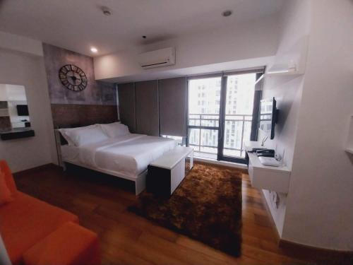 a bedroom with a bed and a clock on the wall at Modern-Eclectic 1BR- Unit @Milano in Manila