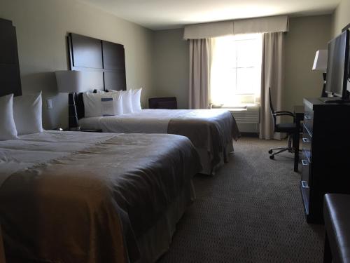 a hotel room with two beds and a window at Baymont by Wyndham College Station in College Station