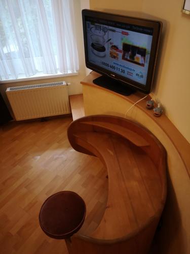 a living room with a tv and a wooden chair at Hotel Wirt Z'Minsta in Altmünster