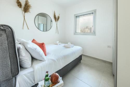 a bedroom with a bed with a mirror on the wall at Luxury 3BR Duplex with Sea View in Tel-Aviv Center by Sea N' Rent in Tel Aviv