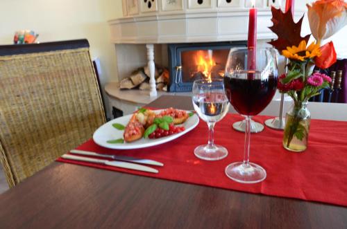 a table with a plate of food and a glass of wine at Hotel Pommerscher Hof in Zinnowitz