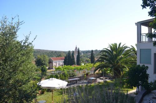 a view of a garden with an umbrella and a building at Casa Muraglia Studio/Studio Under Castle in Travliáta