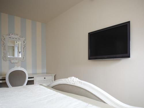 ein Schlafzimmer mit einem Bett und einem Flachbildfernseher an der Wand in der Unterkunft The Broad Leys in Aylesbury
