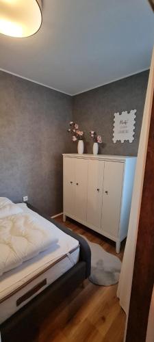 1 dormitorio con 1 cama y 2 jarrones en un armario en Harz mit Herz, Infrarotsauna, E-Kamin, Herzdusche, en Hahnenklee-Bockswiese