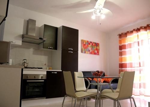 cocina con mesa y sillas en una habitación en St.Joseph Apartment, en Marsaskala