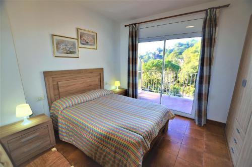 - une chambre avec un lit et une porte coulissante en verre dans l'établissement Villa Isabel Lloret de mar, à Lloret de Mar