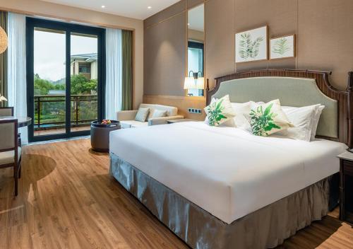 a bedroom with a large bed and a living room at C&D Resort,Wuyi Mountain in Wuyishan