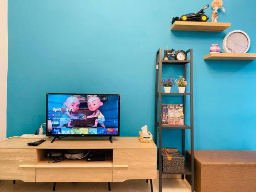 uma televisão de ecrã plano em cima de um centro de entretenimento em madeira em Cozy 3BR Apartment with Free Netflix em Bayan Lepas