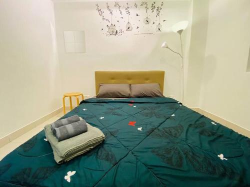 a bed with a blue comforter in a bedroom at Cozy 3BR Apartment with Free Netflix in Bayan Lepas