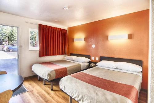 a hotel room with two beds and a table at Motel 6-Mammoth Lakes, CA in Mammoth Lakes