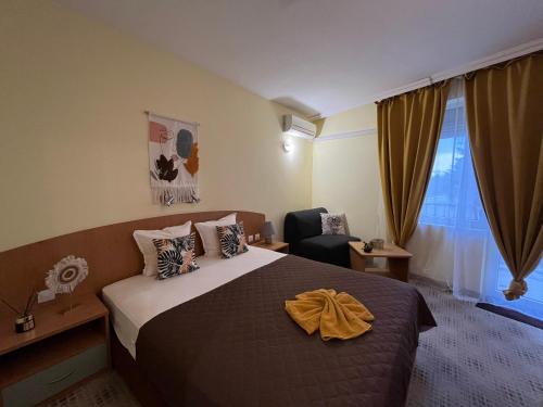 a hotel room with a bed and a chair at Hotel Trakata in Varna City