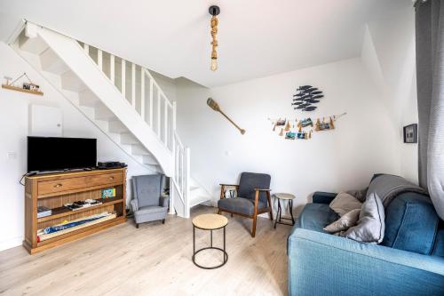 - un salon avec un canapé bleu et un escalier dans l'établissement Duplex du Littoral - Vue mer, à Villers-sur-Mer