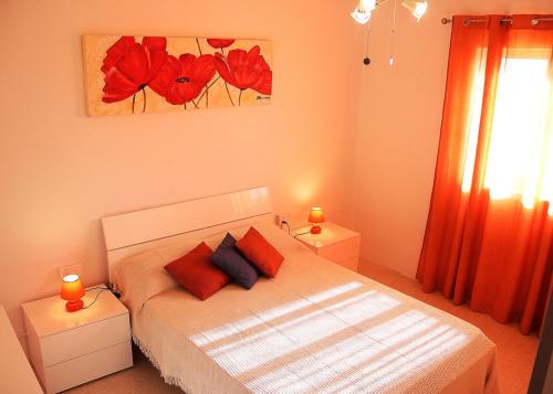 Un dormitorio con una cama con almohadas rojas. en St.Joseph Apartment, en Marsaskala