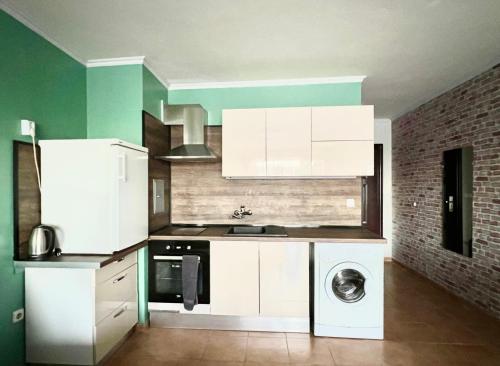 a kitchen with white cabinets and a washing machine at Flower house 2 in Sofia