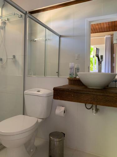 a bathroom with a toilet and a sink and a mirror at Pousada Familiar e Domiciliar - Perto do Aeroporto de Salvador in Lauro de Freitas