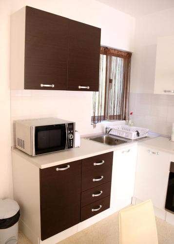 a kitchen with a microwave and a sink at St.Joseph Apartment in Marsaskala
