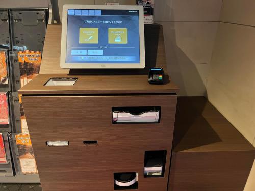 a computer monitor sitting on top of a dresser at Hotel Cerezo in Tokyo