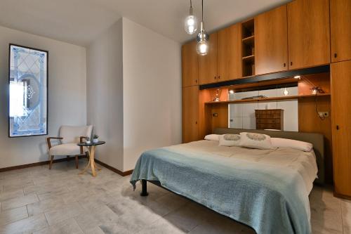 a bedroom with a large bed and a chair at Belvedere Beatrice - Rebomaholidays in Olzano