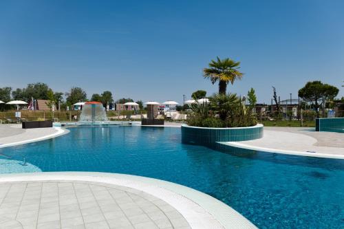 una piscina con una fuente en un complejo en Marina Azzurra Resort, en Lignano Sabbiadoro