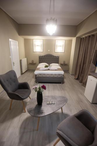 a bedroom with a bed and a table and chairs at Cavallari Palace Hotel Suites in Athens