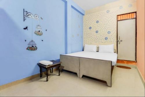 a blue bedroom with a bed and a table at Hotel Radhe Inn By WB Inn in Agra