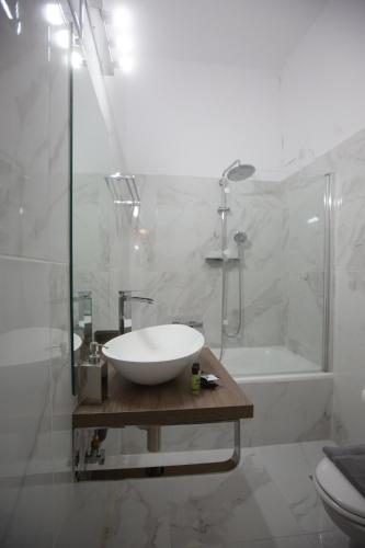 a bathroom with a sink and a shower and a tub at Cavallari Palace Hotel Suites in Athens