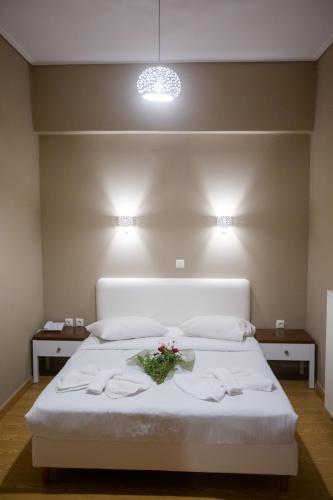 a bedroom with a white bed with flowers on it at Cavallari Palace Hotel Suites in Athens