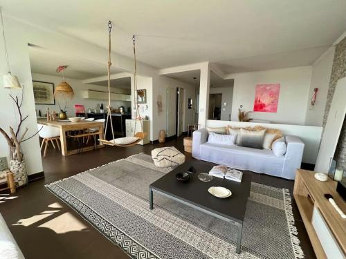 un salon avec un canapé blanc et une table dans l'établissement Maison d'artiste Vue mer & Jacuzzi, à Vallauris