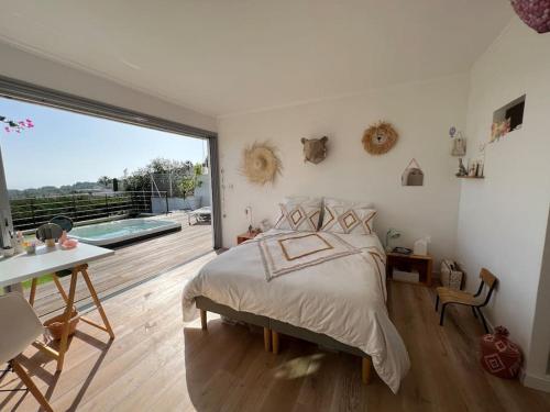 une chambre avec un grand lit et une grande fenêtre dans l'établissement Maison d'artiste Vue mer & Jacuzzi, à Vallauris