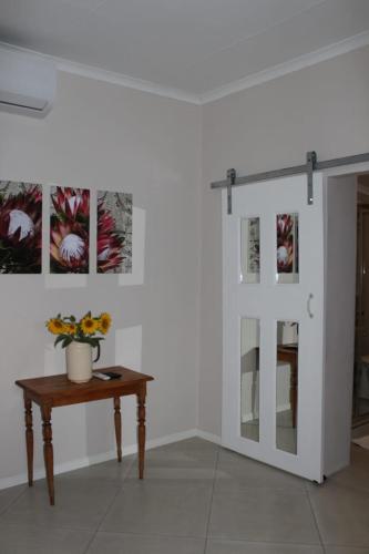 a room with a table and a glass door at Quaggasfontein Gastehuis in Beaufort West