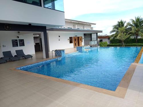 uma grande piscina em frente a uma casa em บ้านไอรัก@the neo 