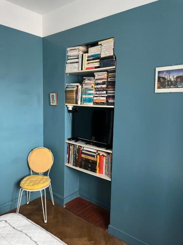 Cette chambre est dotée d'un mur bleu, d'une télévision et d'une chaise. dans l'établissement France Nice Promenade Des Anglais 80m² Piano, à Nice